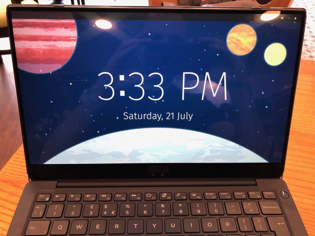 The Pop!_OS lock screen showing a beautifully illustrated space scene with planets and the current time (3:33PM on Saturday, 21 July)