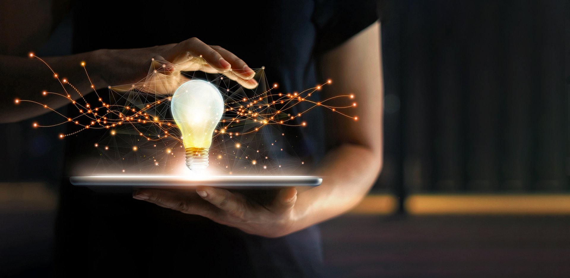 Image of a person conjuring a networked lightbulb from an iPad