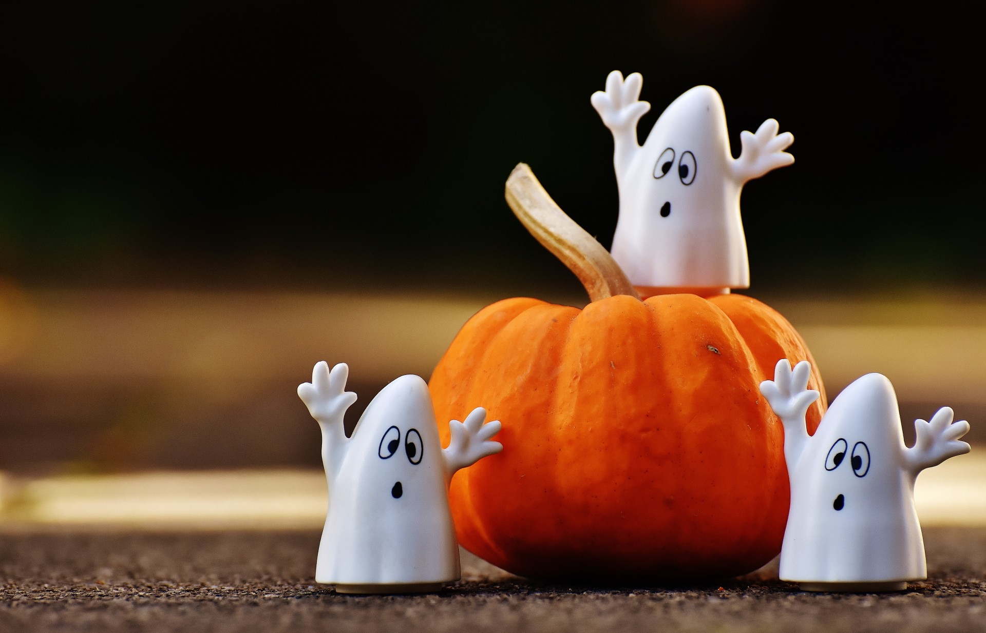 Photo of pumpkin and three ghost figurines.